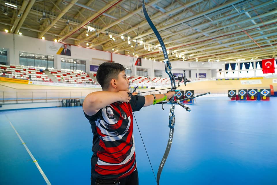 Genç sporcu velodrom salonunda olimpik yayla çekiş yapıyor