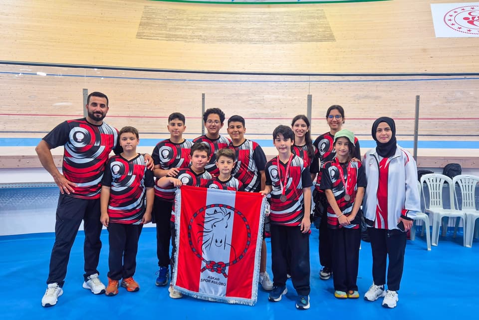 Kulüp formalı sporcular ve antrenörler, Aşkar bayrağıyla takım fotoğrafı
